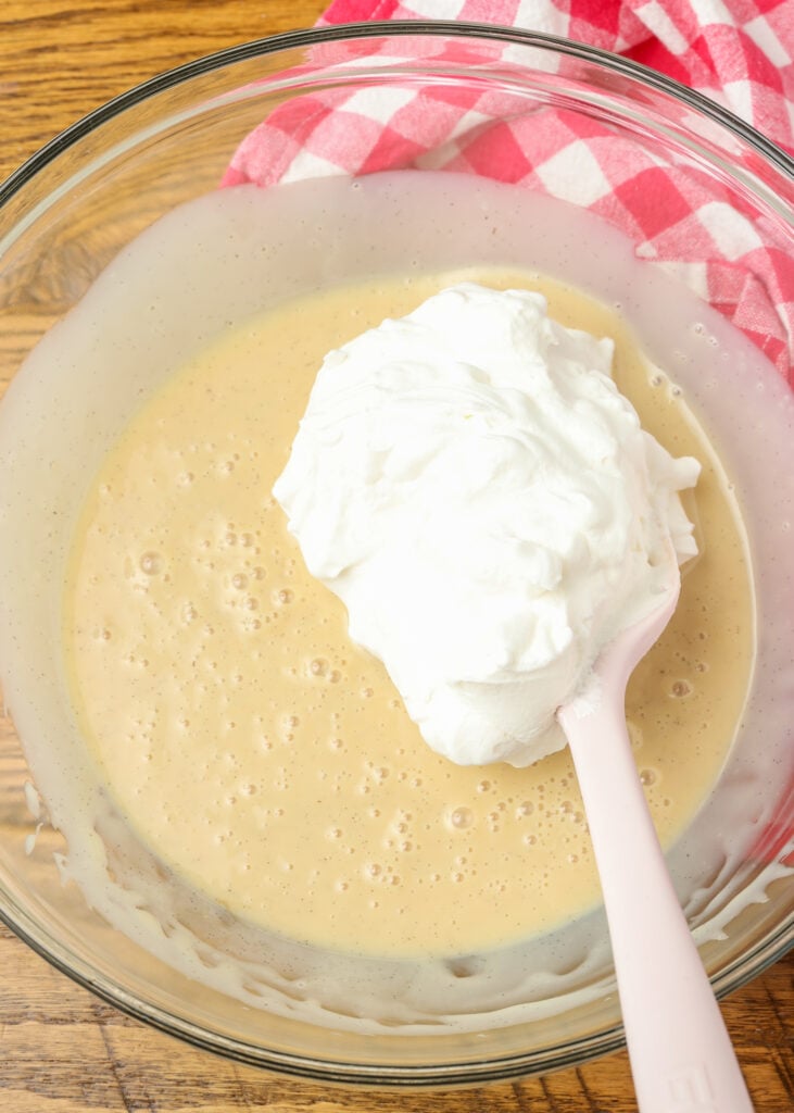 adding whipped cream to ice cream base in mixing bowl